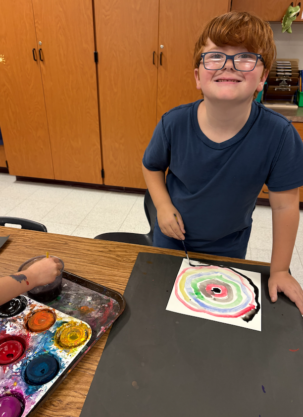 little boy painting in art class