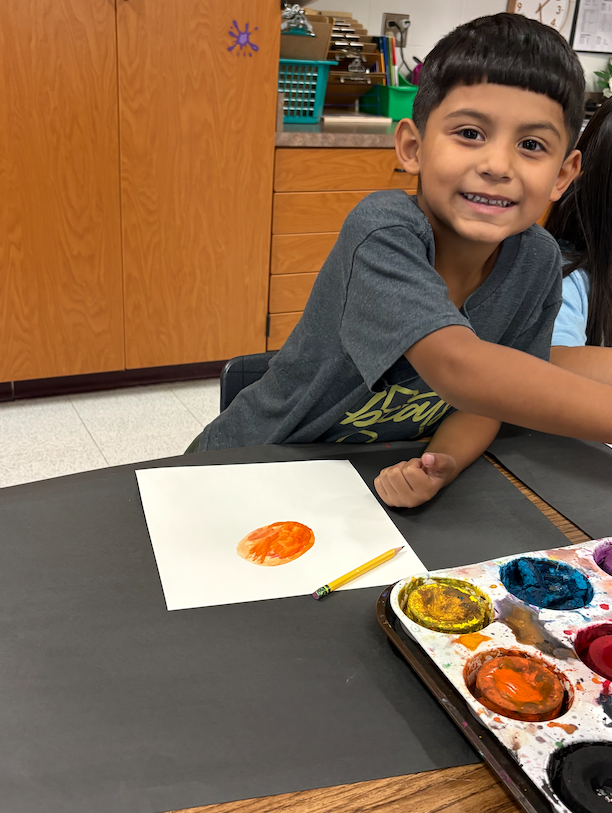 little boy painting in art class 