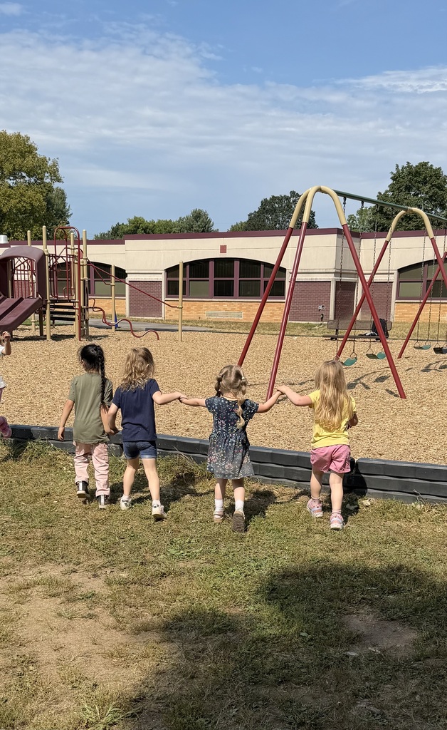 four little girls holding hands, their backs to the camera