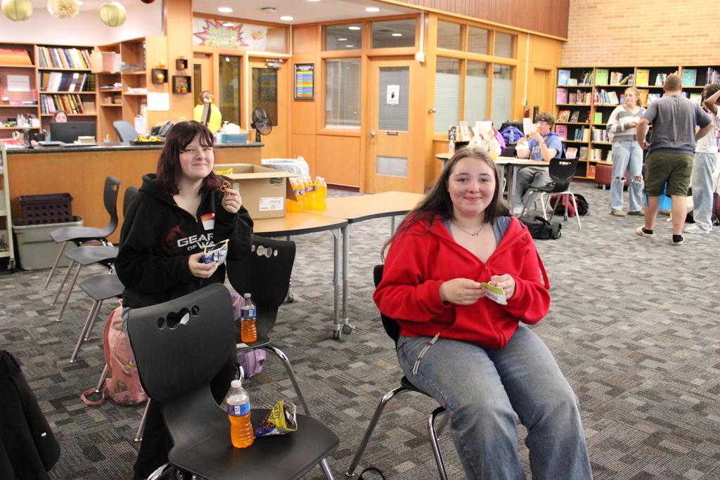 two female students sitting at a chair 