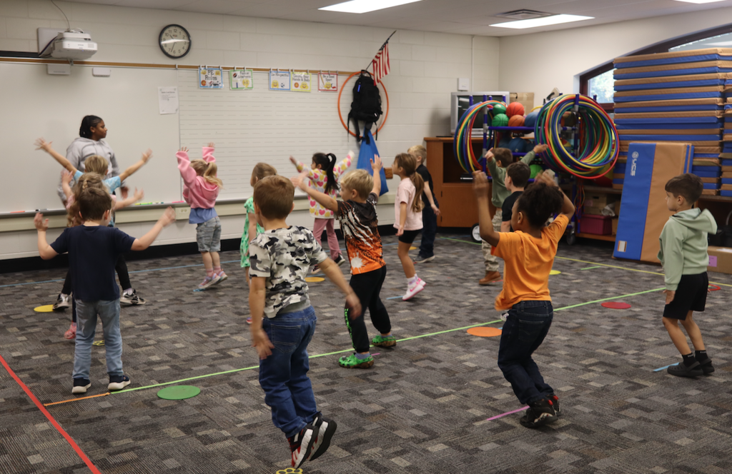 class doing jumping jacks in classroom