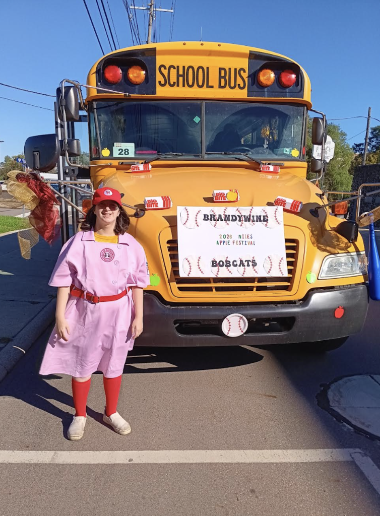 bus driver in baseball uniform in front of bus