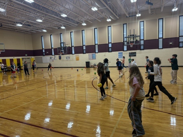 group of kids in the gym playing dodgeball