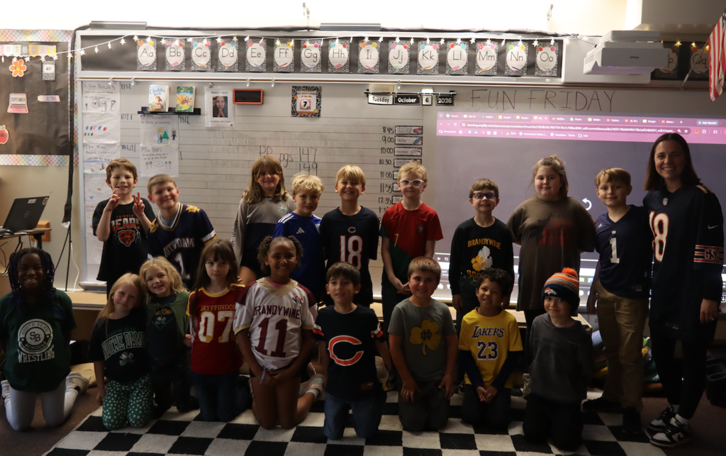 group of second graders with teacher in sports jerseys