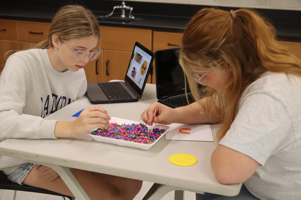 two girls playing with beads