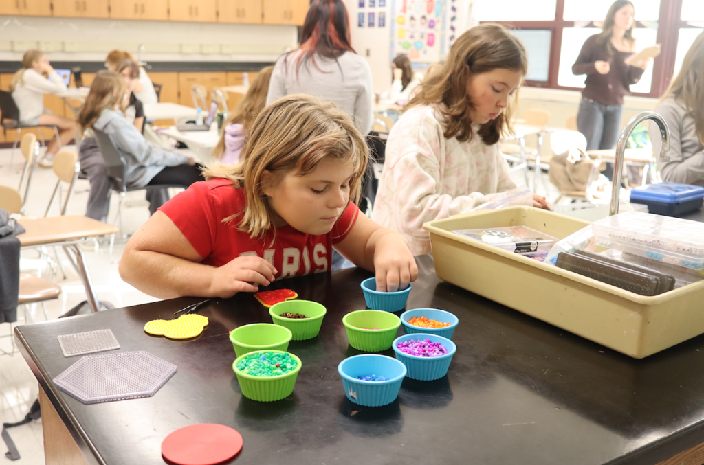 group of girls working with beads