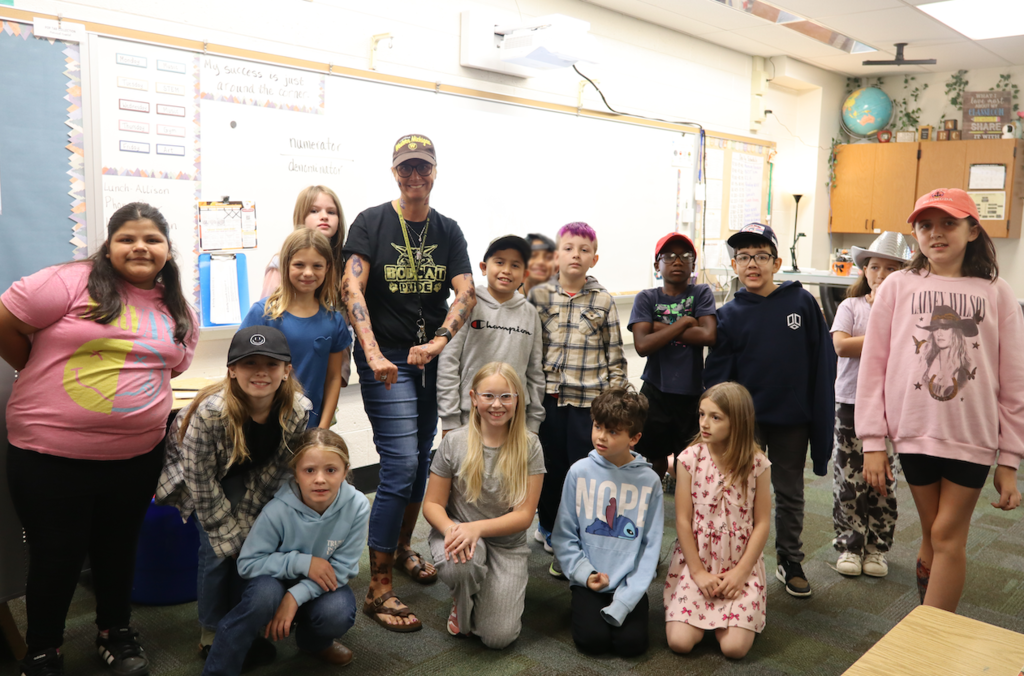 gorup of kids with their teacher who is wearing a bunch of tattoos