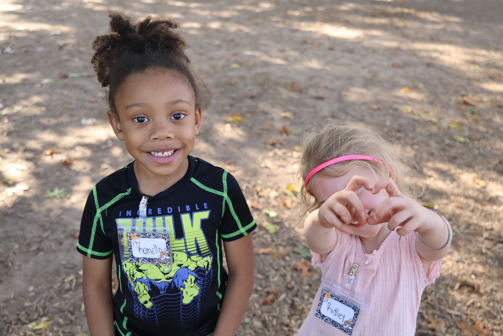 two little kiddos on the playground smiling