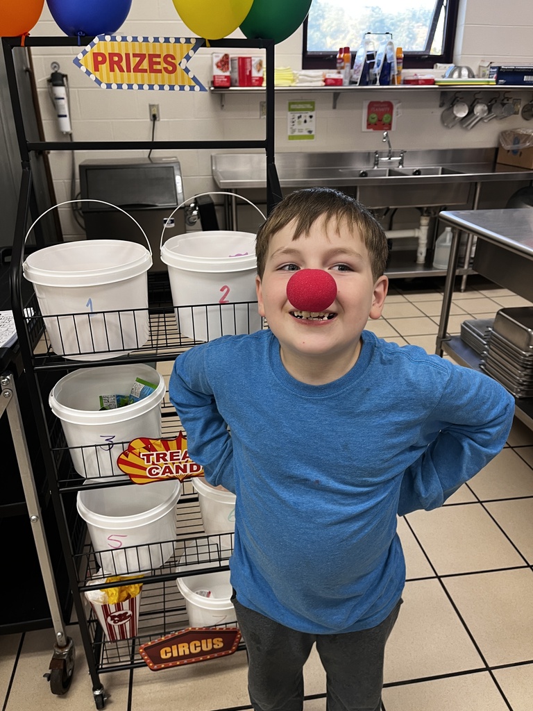 little boy wearing a clown nose