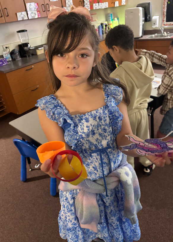 young girl holding paper dragon and paper chain