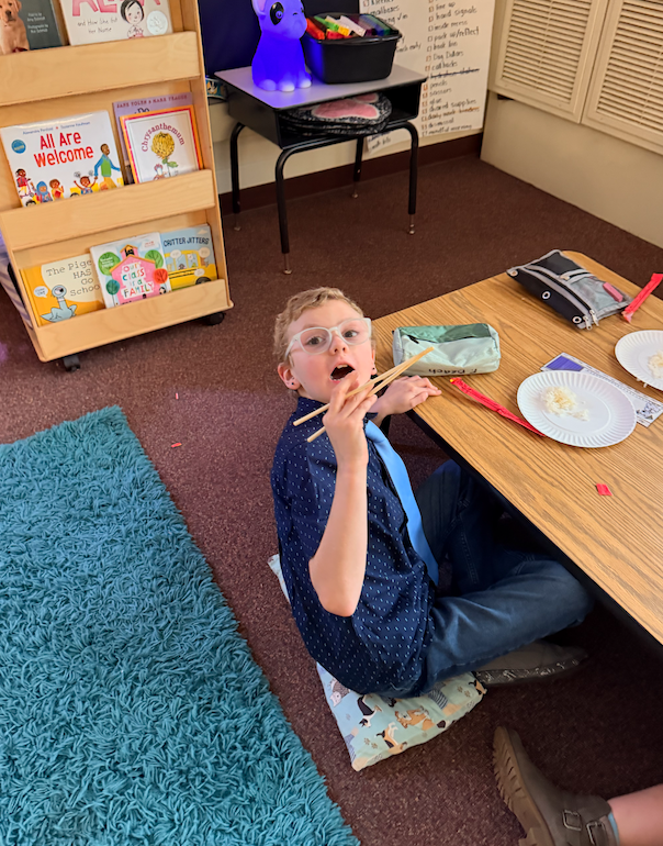 little boy trying chopsticks