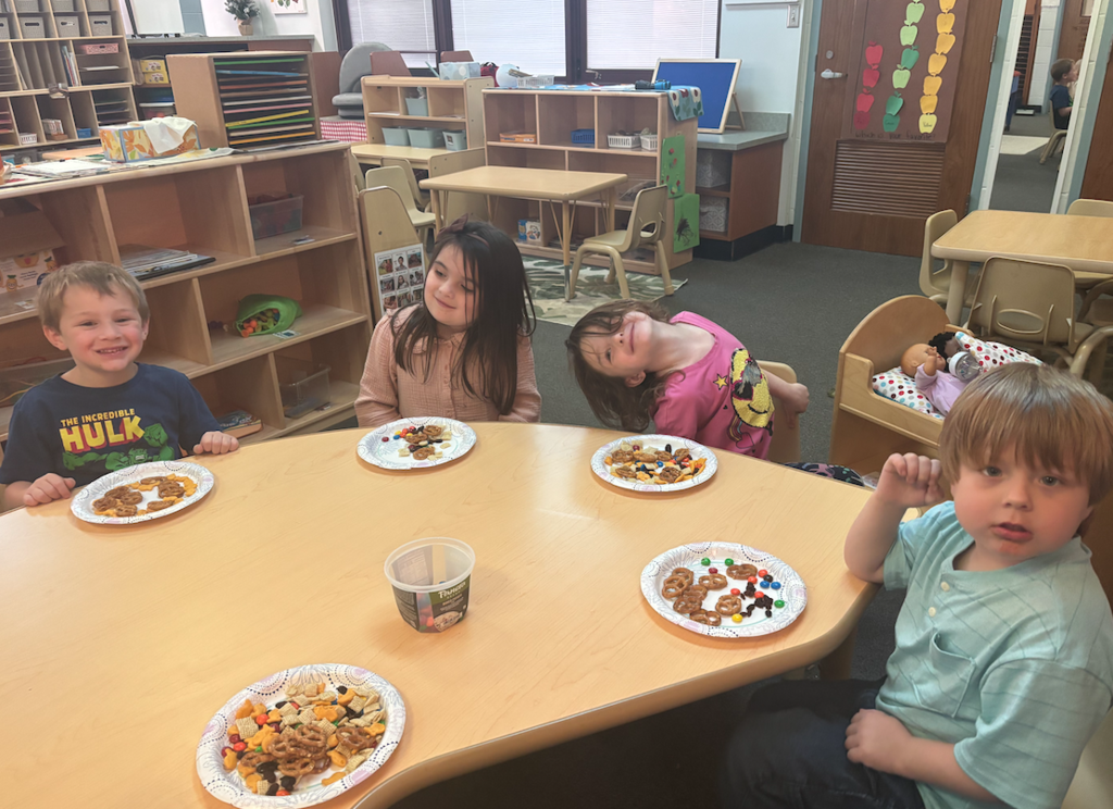 four kids sitting at their table with trail mix