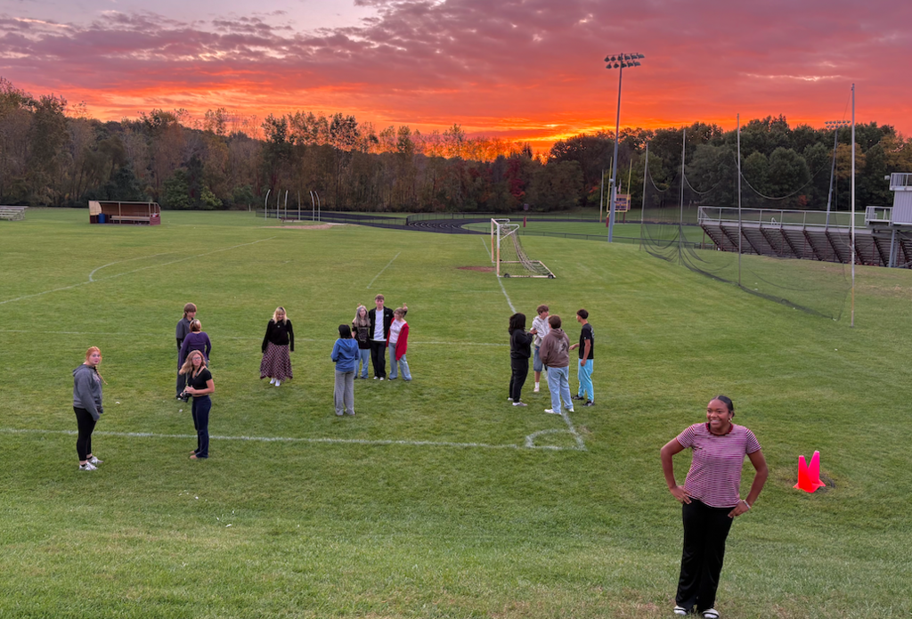 group of kids outside on field with pretty sunrise
