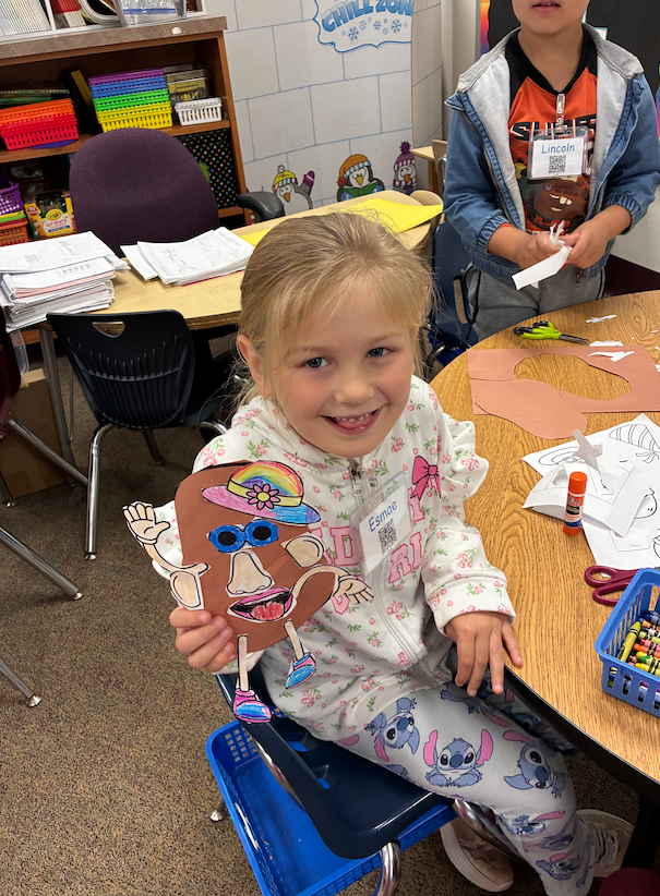 little girl holding paper mrs. potato head