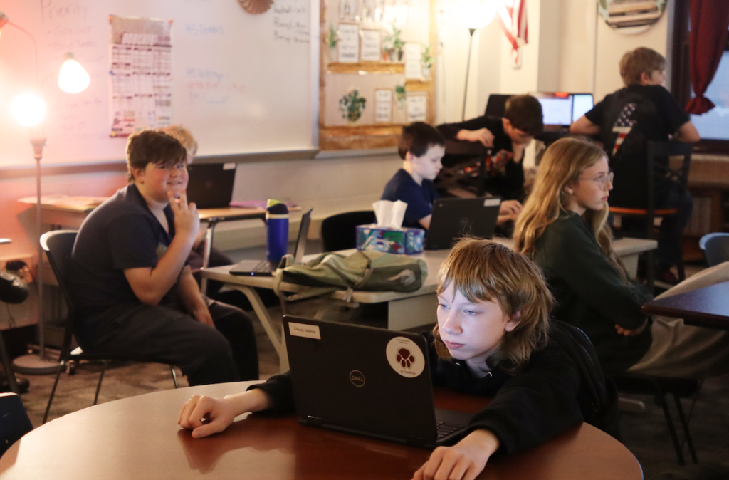 students sitting at desks with laptops