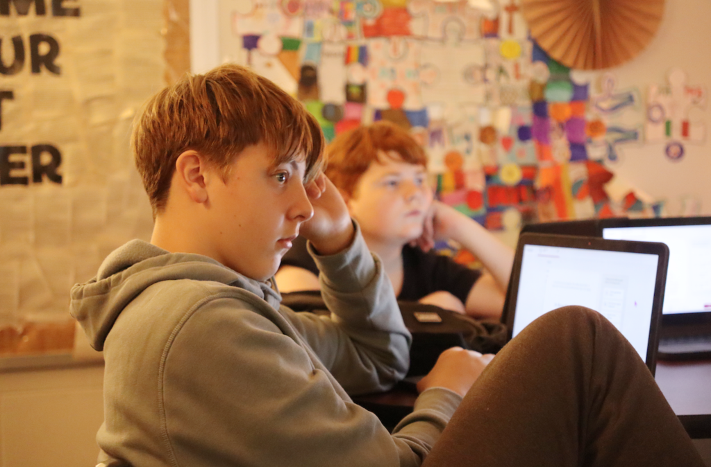 student sitting at desk with laptop