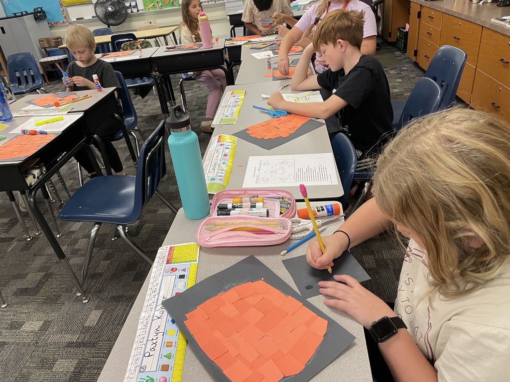 kids at desk working on pumpkins