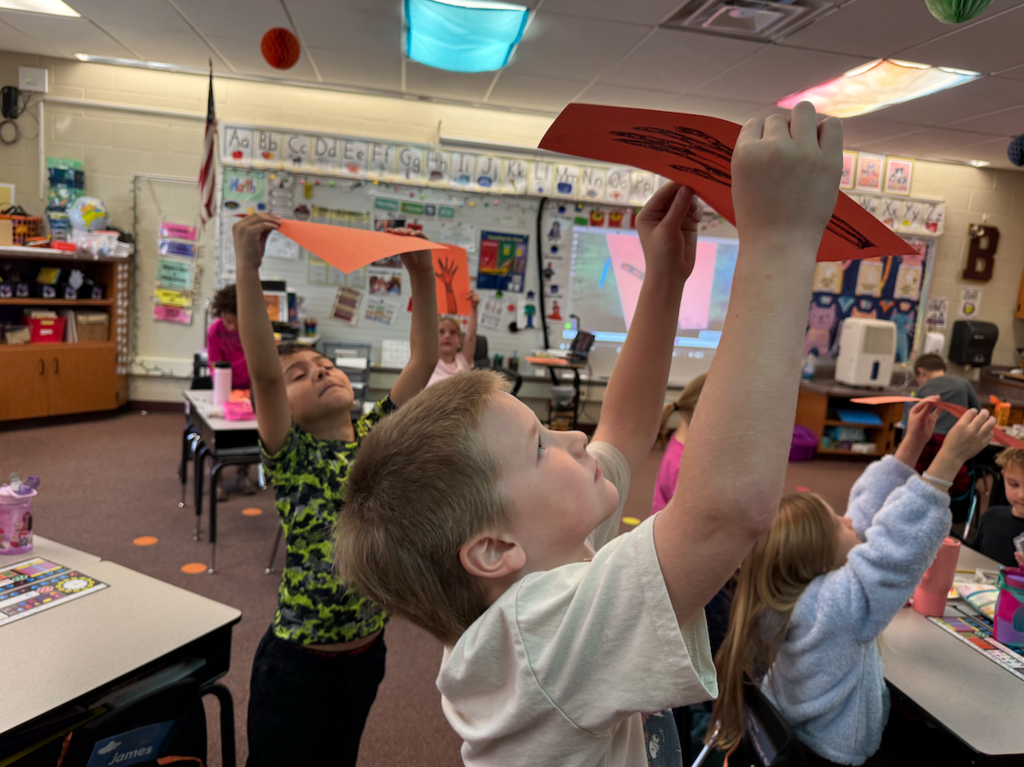 little boy holding hand drawing up to the light