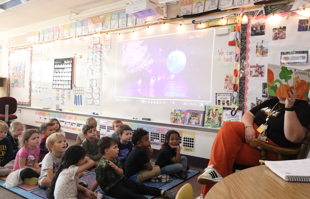 class sitting on the carpet listening to a story