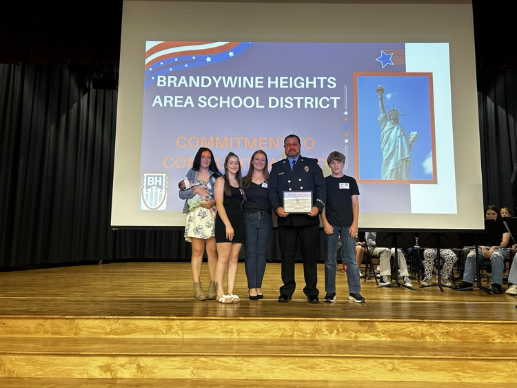 award recipient stands with students