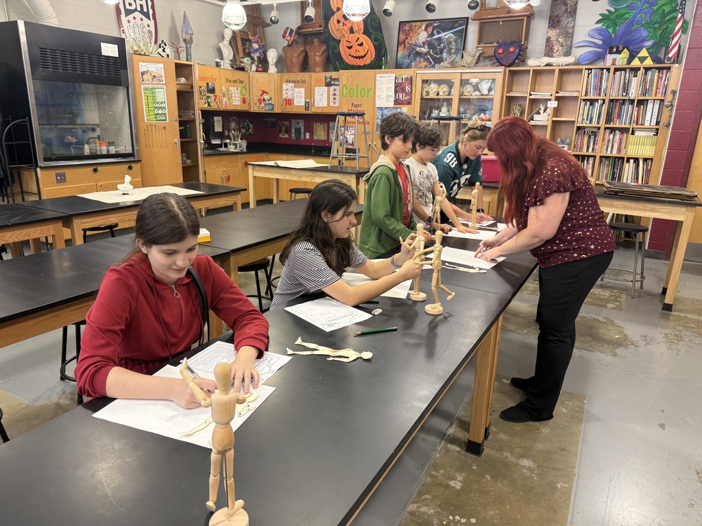 Students use manikins to inspire their characters pose.