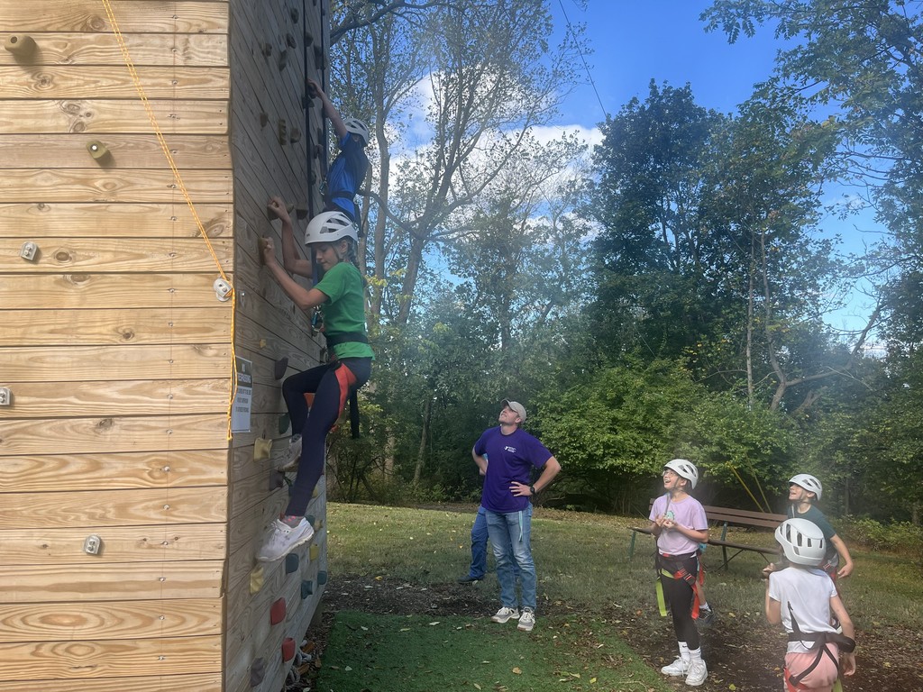 students watch other students do the climbing wall