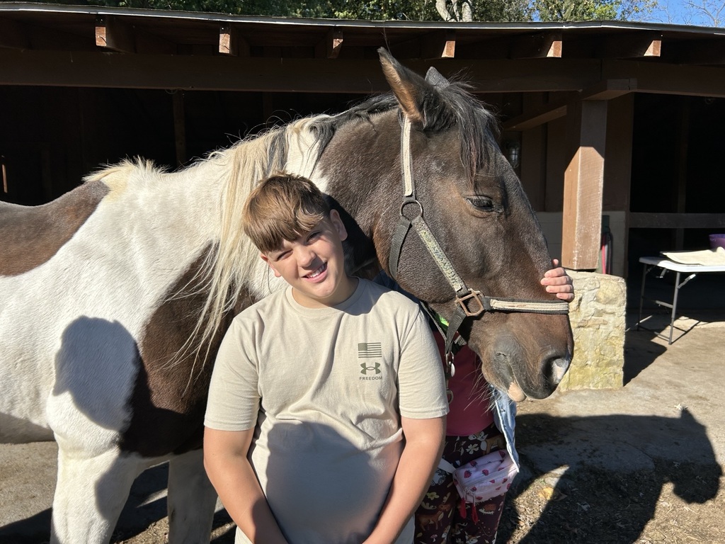 student stands with a horse