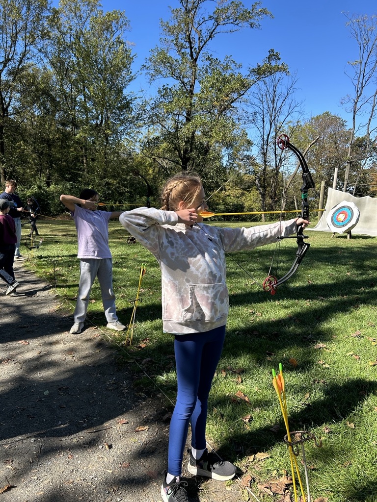 student shoots a bow and arrow