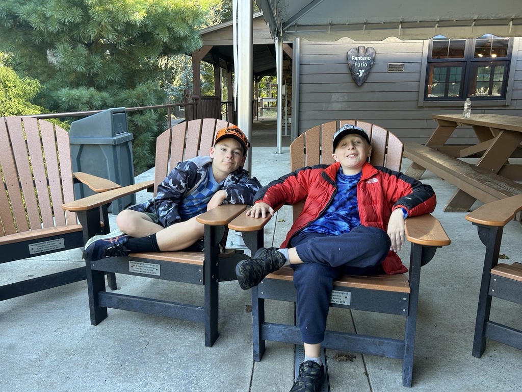 two students sit in adirondack chairs