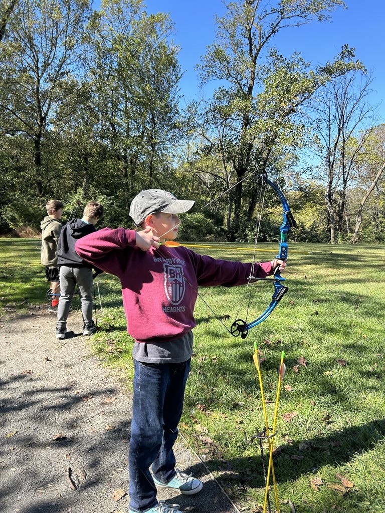 student shoots bow and arrow