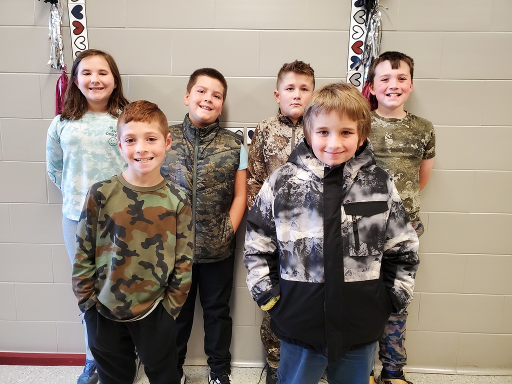 6 students standing together wearing camo