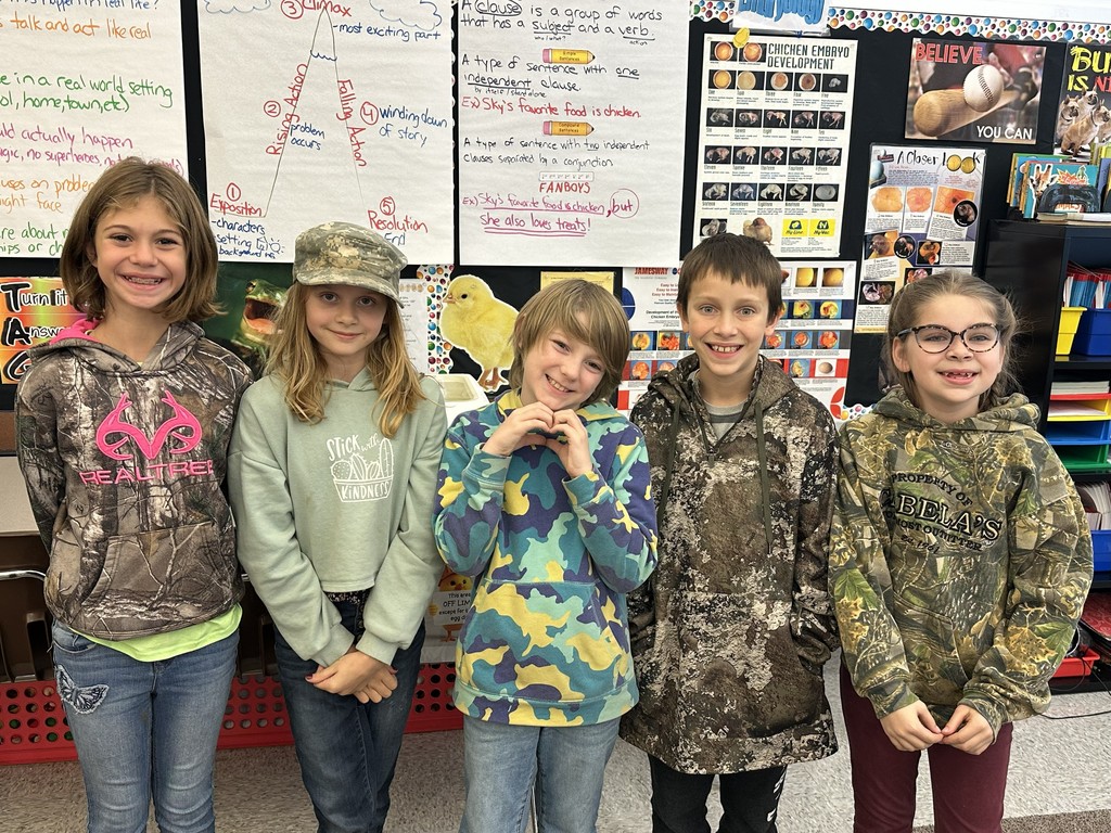 five students standing together wearing camo