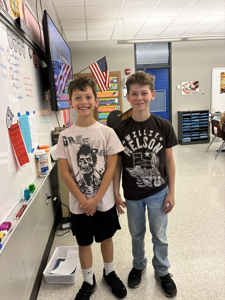 two students stand wearing band shirts