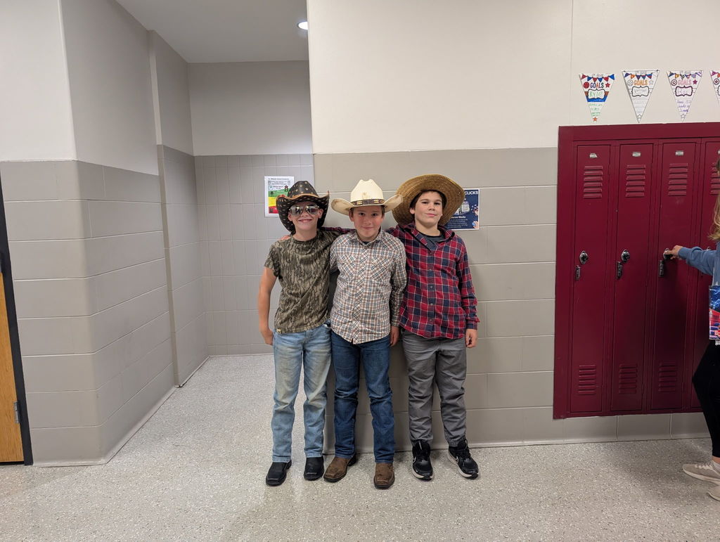 three students in cowboy attire stand together