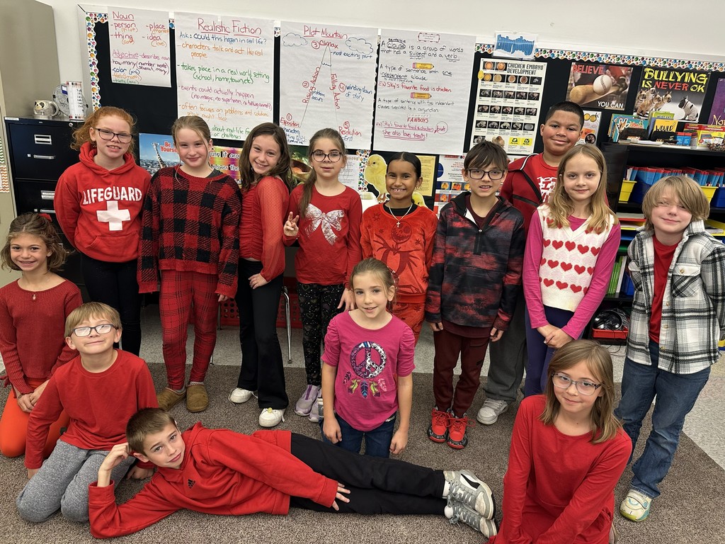 students stand together all wearing red