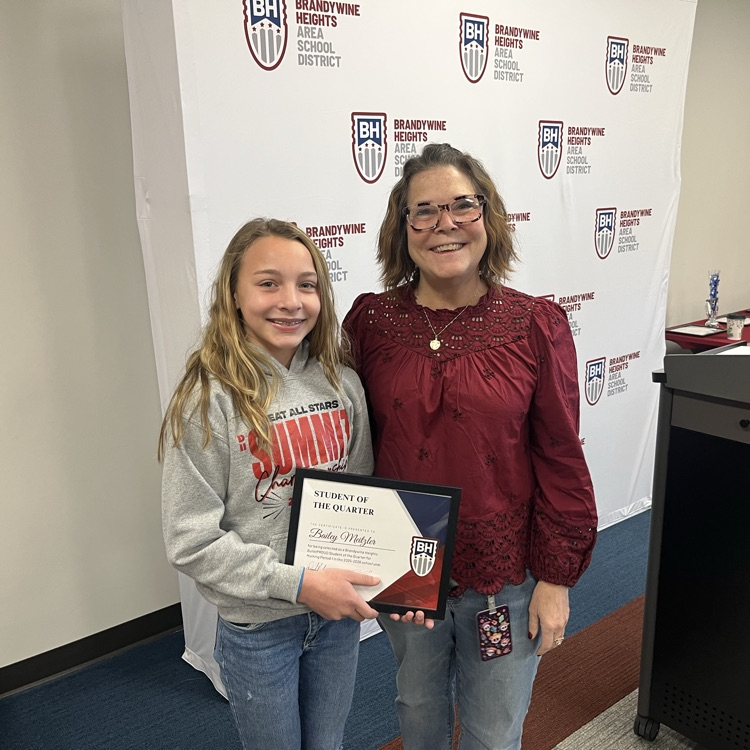 student with certificate stands with teacher