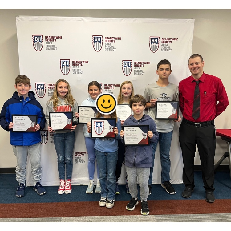 student with certificate stands with teacher