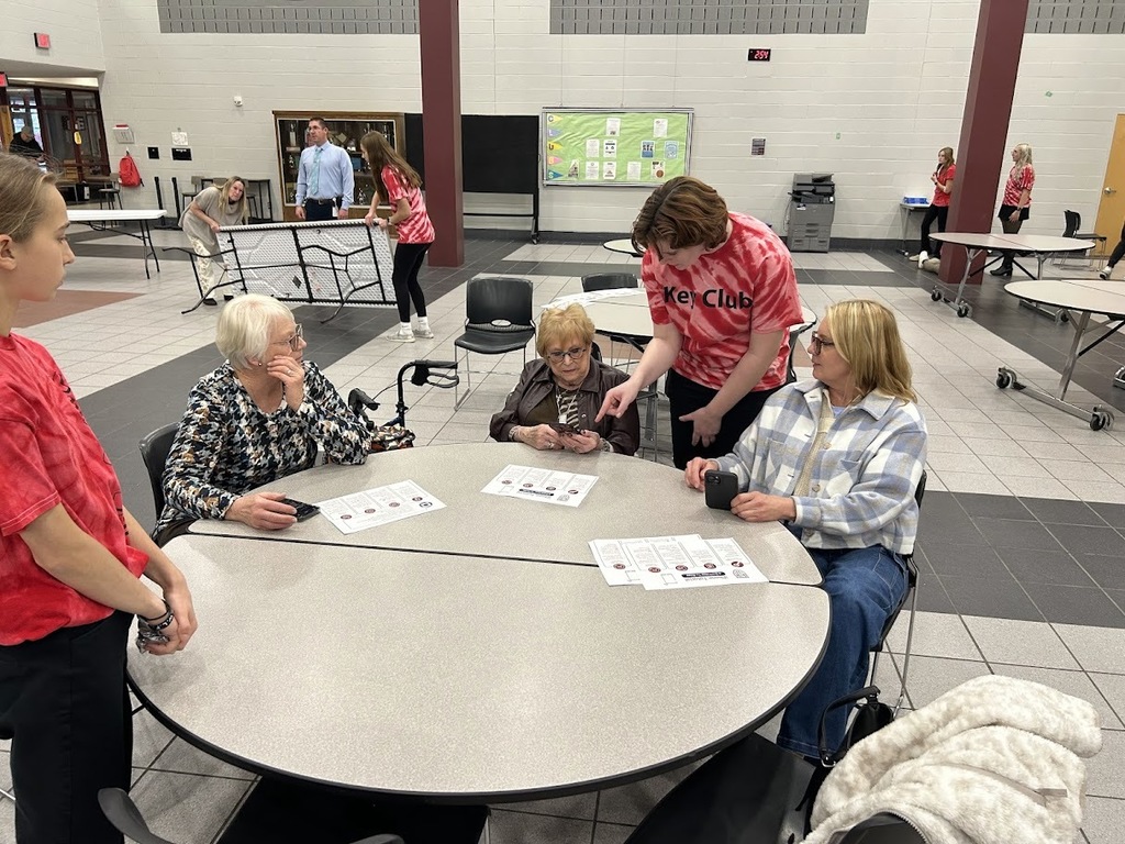 Student helps a senior citizen with his smartphone.