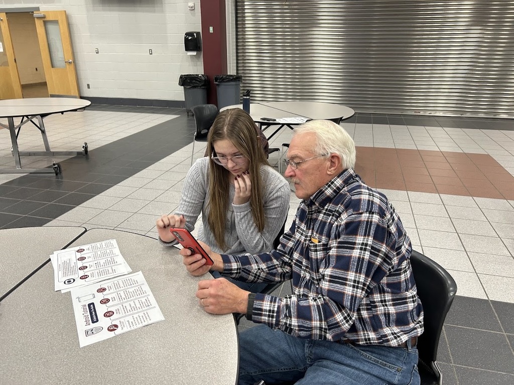 Student helps a senior citizen with his smartphone.