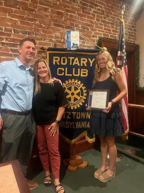 Kamryn Henry and her parents in front of the Kutztown Rotary Sign.