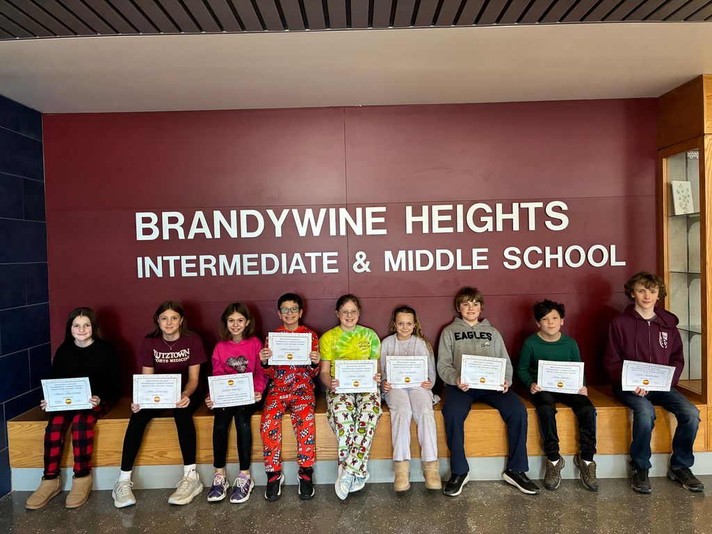 students sit with certificates