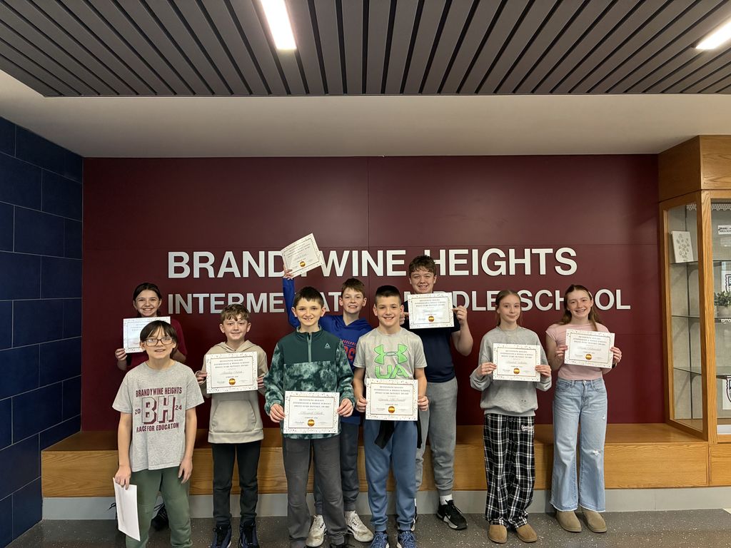 students stand holding certificates