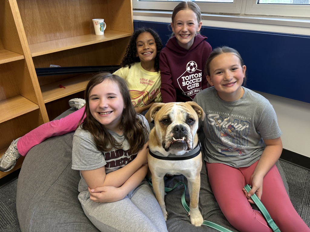 4 students smile alongside of a bulldog
