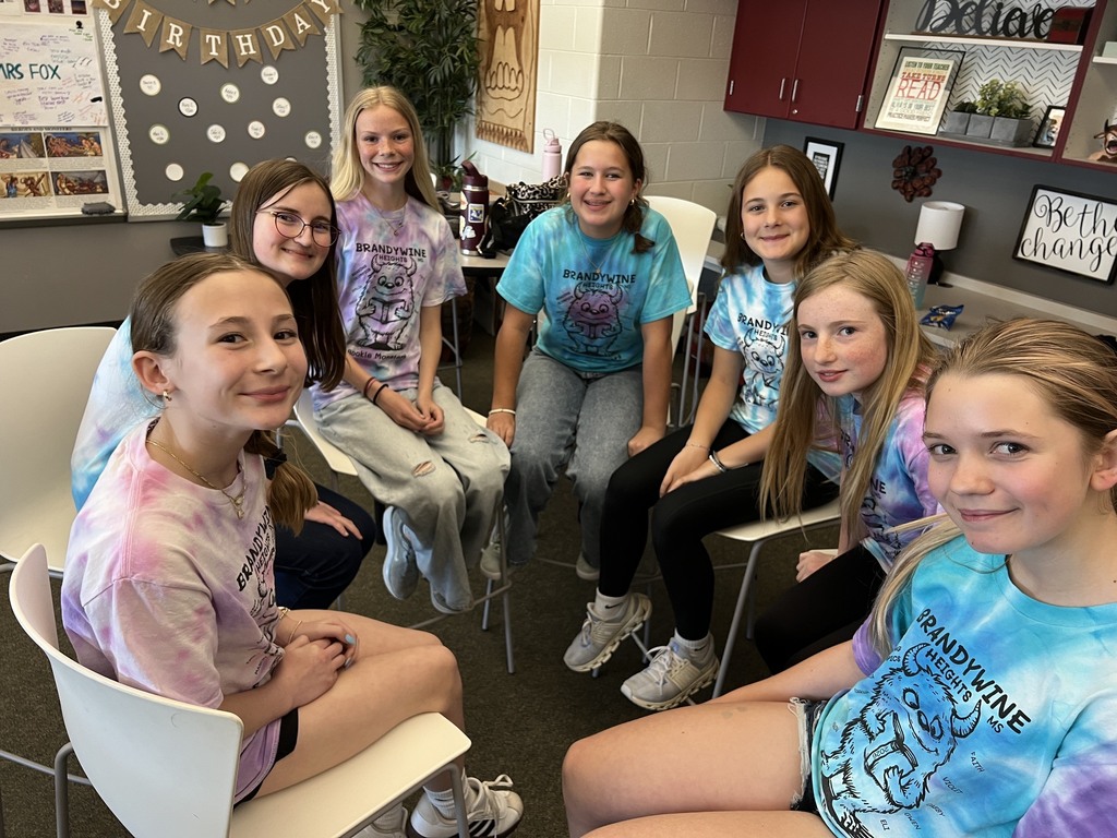 7 students sit in a circle smiling