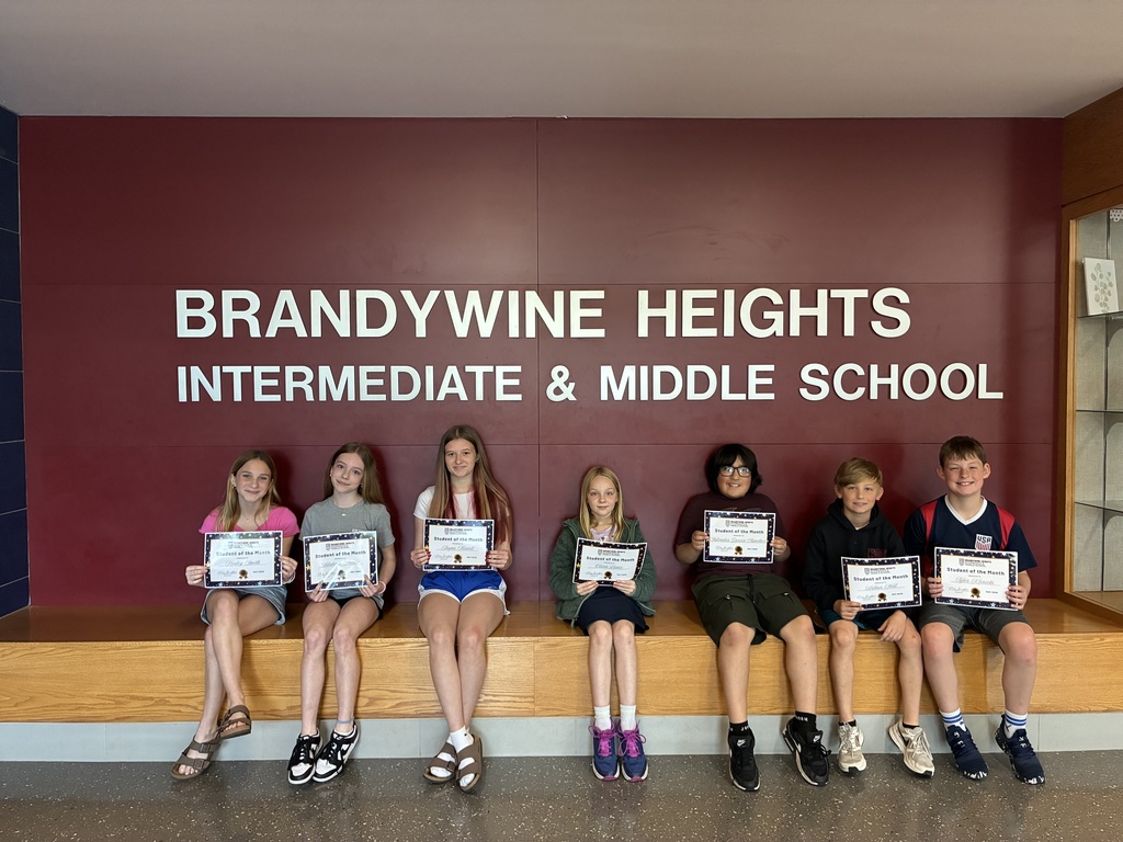 7 students sitting holding certificates