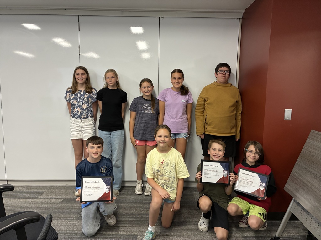 9 students sit and stand smiling