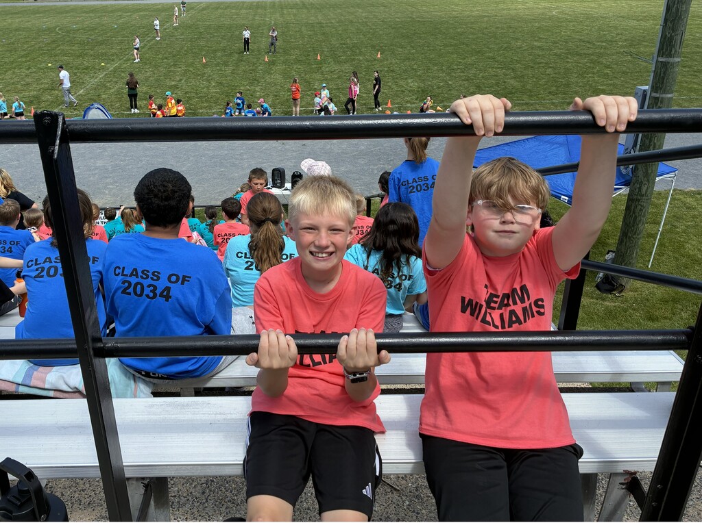 two students sitting on bleachers