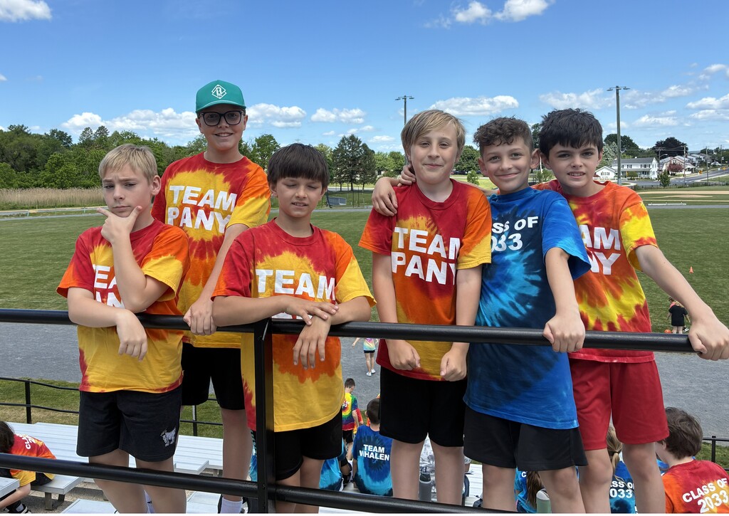 six students stand together on bleachers