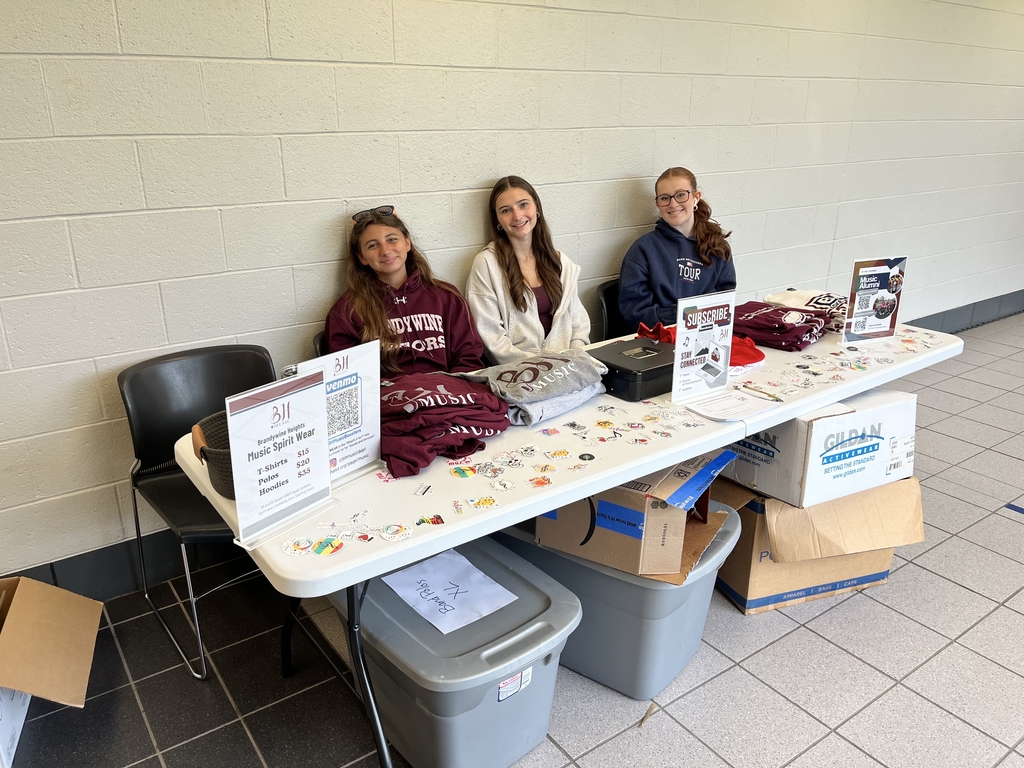 Tri-M Music Honor Society students sitting at a music department table