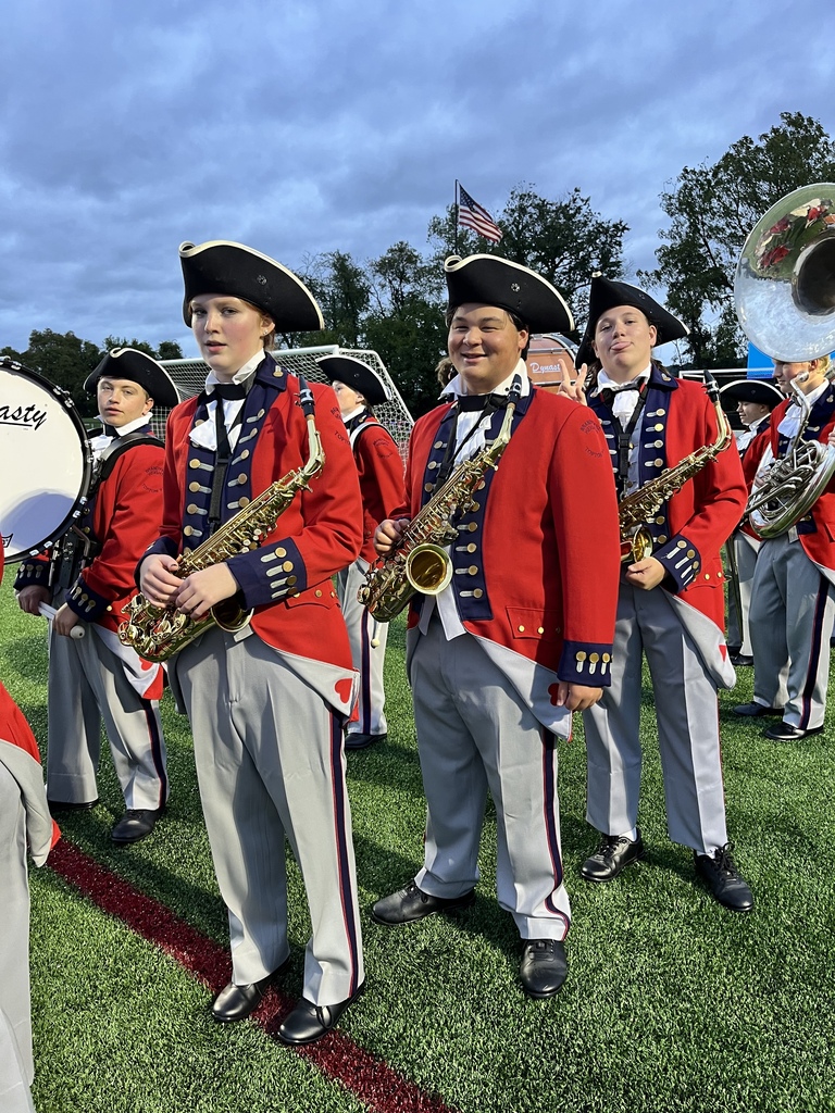 Marching Band students standing and posing on the field